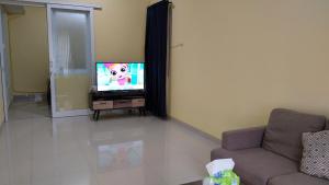 a living room with a tv and a couch at Hans Bali Guest House in Jimbaran