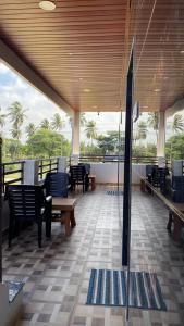 a room with chairs and tables and a balcony at Mamatha Guest inn in Hampi