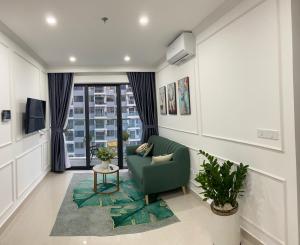 a living room with a green couch and a window at Moon homestay, apartment Hue in Hue