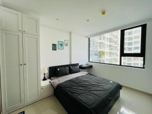 a bedroom with a black bed and a window at Moon homestay, apartment Hue in Hue