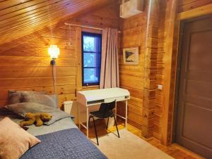 a bedroom with a desk and a bed with a teddy bear on the bed at Kolin Runo in Yläkoli