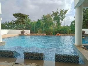 a large swimming pool with blue water at Condo de Avila in Boracay