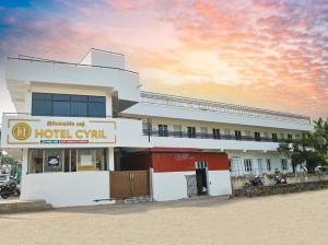um edifício com um hotel vivill com um pôr-do-sol em HOTEL CYRIL em Kanyakumari