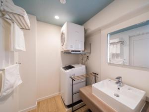 a bathroom with a sink and a washer and dryer at Aqua Palace Chatan by Coldio Premium in Chatan