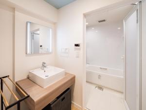 a white bathroom with a sink and a shower at Aqua Palace Chatan by Coldio Premium in Chatan +37 photos