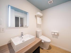 a white bathroom with a sink and a toilet at Aqua Palace Chatan by Coldio Premium in Chatan