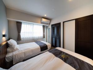 Кровать или кровати в номере Aqua Palace Chatan by Coldio Premium