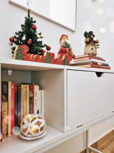 a shelf with a christmas tree and books at Tiber Rooms Testaccio in Rome