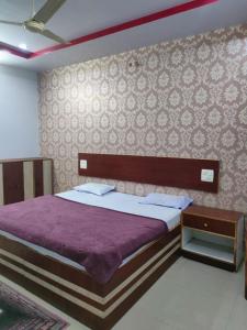 um quarto com uma cama grande e um cobertor roxo em HOTEL KANHA INTERNATIONAL, Anuppur em Anūppur