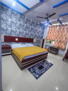 um quarto com uma cama grande e um cobertor amarelo em HOTEL KANHA INTERNATIONAL, Anuppur em Anūppur