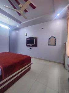 um quarto com uma cama e uma televisão na parede em HOTEL KANHA INTERNATIONAL, Anuppur em Anūppur