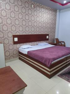 um quarto com uma cama com um edredão roxo em HOTEL KANHA INTERNATIONAL, Anuppur em Anūppur
