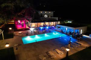 una vista panoramica su una piscina di notte di Hôtel Les Séquoias a Ruy