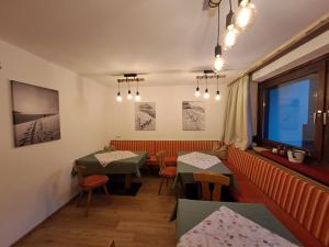 een restaurant met 2 tafels en stoelen en een raam bij Berghaus Praxmarer in Längenfeld