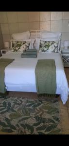 a large white bed with two pillows on it at Mpucuko Guest House in Mtubatuba