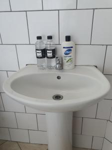 a bathroom sink with two bottles of water on it at Mpucuko Guest House in Mtubatuba