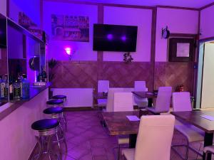 restauracja z fioletowym oświetleniem, stołami i krzesłami w obiekcie City Hotel West w Frankfurcie nad Menem