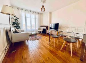 a living room with a couch and a table at Appartement neuf, au calme, proche métro in Boulogne-Billancourt