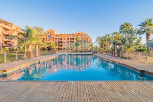 莫特里爾的住宿－Playa Granada Motril Beach and Golf，棕榈树和建筑度假村内的游泳池