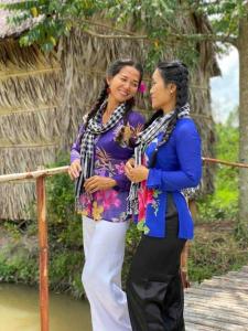 zwei Frauen stehen nebeneinander auf einer Brücke in der Unterkunft MEKONG DANIEL HOMESTAY CAN THO in Cần Thơ