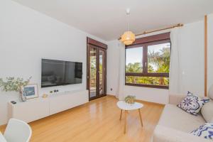a living room with a tv and a couch and a table at Playa Granada Motril Beach and Golf in Motril