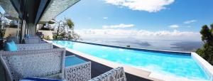 einen Pool mit Stühlen und Meerblick in der Unterkunft The Lake Hotel Tagaytay in Tagaytay