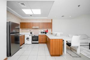 a kitchen with wooden cabinets and a stainless steel refrigerator at ALH VAcay - Sulafa Tower - 1 Bedroom in Dubai