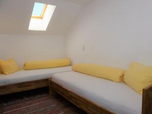 um quarto com 2 camas com almofadas amarelas e uma janela em Apartment in Krimml with a balcony or terrace em Krimml