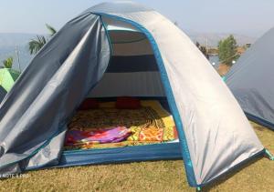 a tent with a bed inside of it at Pawna lake Camping Lonavala in Kolvan