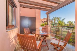 莫特里爾的住宿－Playa Granada Motril Beach and Golf，阳台的天井配有桌椅