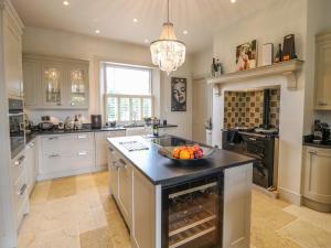 a kitchen with an island with a bowl of fruit on it at The Coach House in Grantham