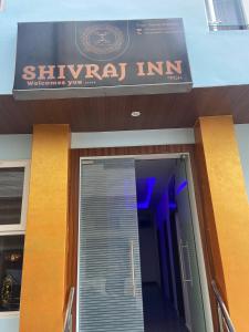 a sign for a shynazi inn on a building at Shivraj Inn in Varanasi