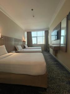 una camera d'albergo con due letti e una grande finestra di Nawazi Towers Hotel a La Mecca