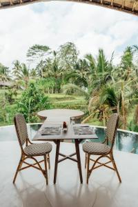 a table and two chairs on a patio at Daun Lebar Villas in Payangan
