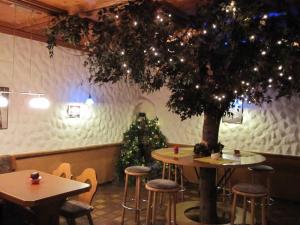 a christmas tree in a restaurant with a table and stools at Alemannenhof Hotel Engel in Rickenbach