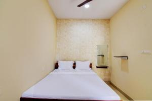 Cama en habitación pequeña con 2 almohadas blancas en OYO Hotel Lake View en Ranchi