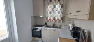 a small kitchen with a sink and a stove at Sun-n-Waves Holidaymakers in Rafina