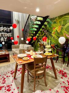 a dining room with a table and a staircase at FlowerGod PentStudio Tay Ho Hanoi in Hanoi