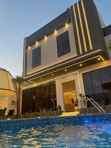 una casa con piscina di fronte a un edificio di شاليه الرتاج الفندقي a Buraydah