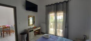 a bedroom with a bed and a desk and a window at Sun-n-Waves Holidaymakers in Rafina