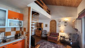 a kitchen with a living room with a couch and a table at La Golette Apartment in La Thuile