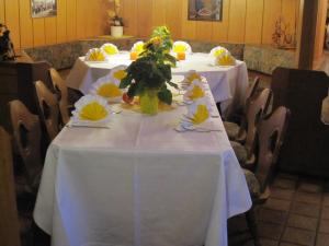 einen Tisch mit weißem Tischtuch und Blumen darauf in der Unterkunft Alemannenhof Hotel Engel in Rickenbach