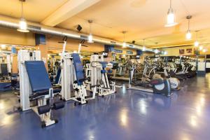 a gym with rows of treadmills and machines at Danubius Hotel Arena in Budapest