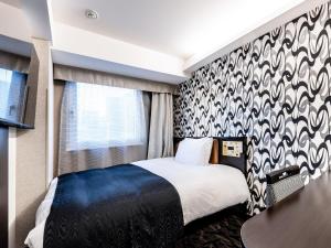 a bedroom with a bed with a black and white patterned wall at APA Hotel Kayabacho Hachobori Ekimae in Tokyo