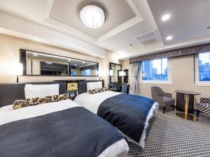 a hotel room with two beds and a table at APA Hotel Kayabacho Hachobori Ekimae in Tokyo