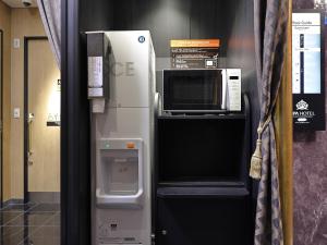 a microwave oven sitting on top of a refrigerator at APA Hotel Kayabacho Hachobori Ekimae in Tokyo