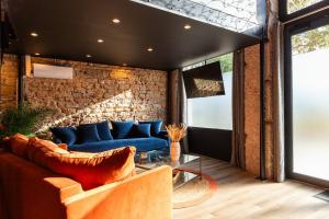 a living room with a blue couch and a brick wall at SmartStay Bird Family - Lyon in Lyon