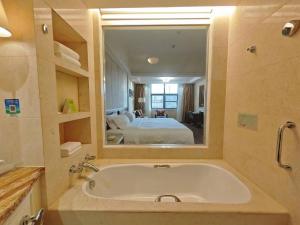 La salle de bains est pourvue d'une baignoire avec un grand miroir. dans l'établissement Holiday Inn Fuzhou New Port, an IHG Hotel, à Fuzhou