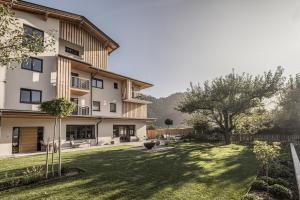 un grand bâtiment avec une cour arborée dans l'établissement Zeit.Glück Appartements, à Radfeld