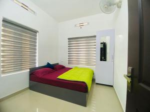 a bedroom with a bed with a yellow and red blanket at starhive in Kalpetta